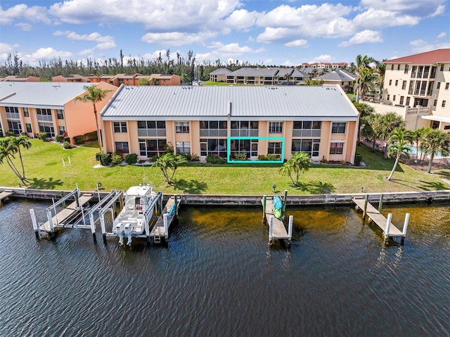 view of dock featuring a water view, boat lift, a residential view, and a lawn