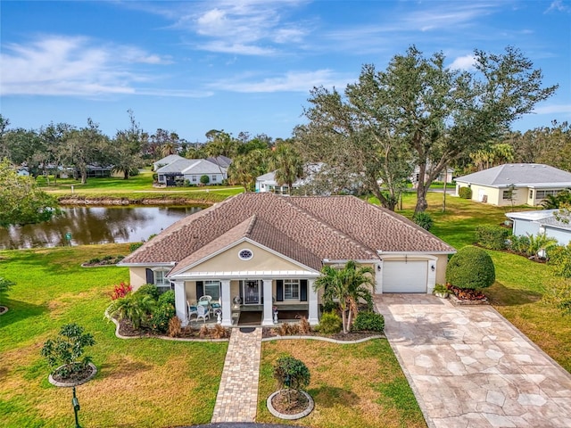 view of front of house with a garage, concrete driveway, a water view, a porch, and a front yard