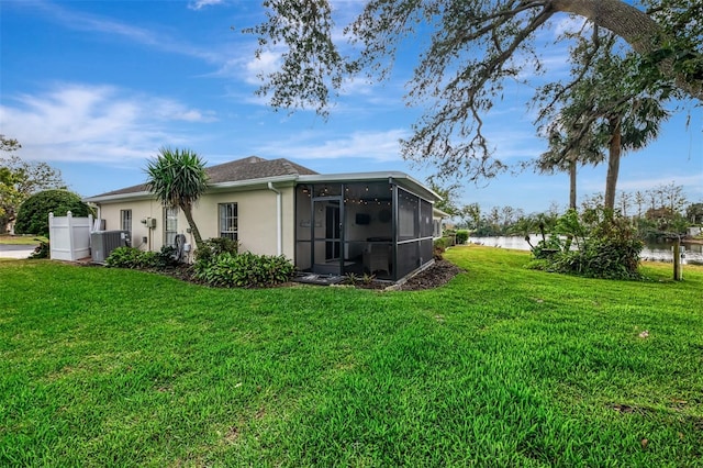 3 Bermuda Cir Unit 49, Englewood, FL 34223 - back of house with a sunroom, a yard, stucco siding, and a water view