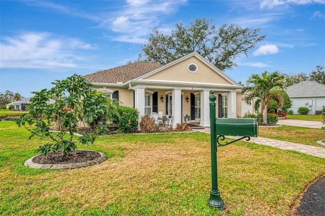 3 Bermuda Cir Unit 49, Englewood, FL 34223 - neoclassical / greek revival house featuring stucco siding, a front yard, and a porch
