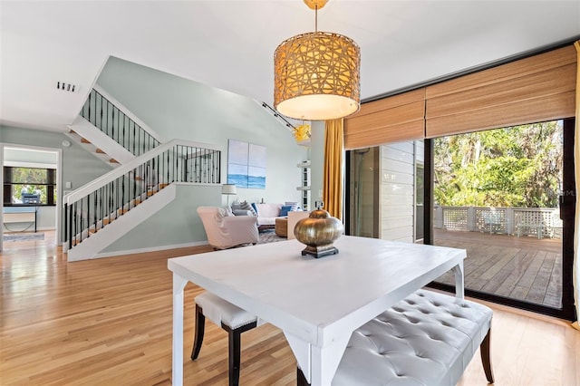 dining space featuring stairway, visible vents, and light wood-style flooring