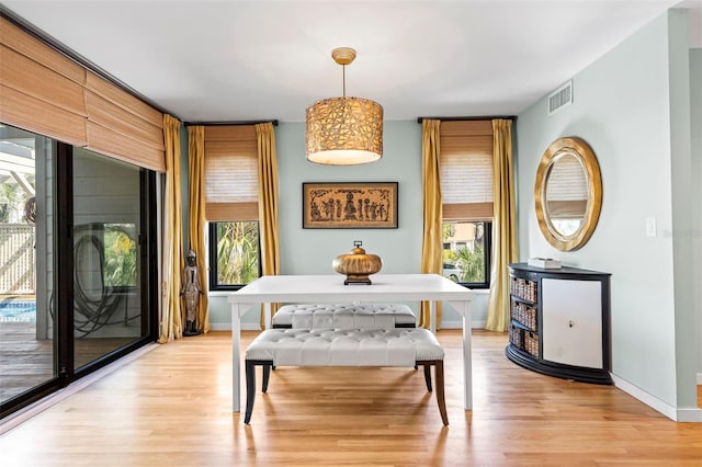 dining room featuring a wealth of natural light, light wood-style flooring, visible vents, and baseboards