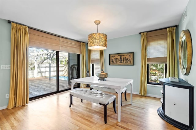 dining space featuring light wood-style flooring and baseboards