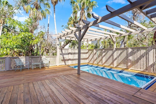 wooden deck with a fenced in pool and a pergola