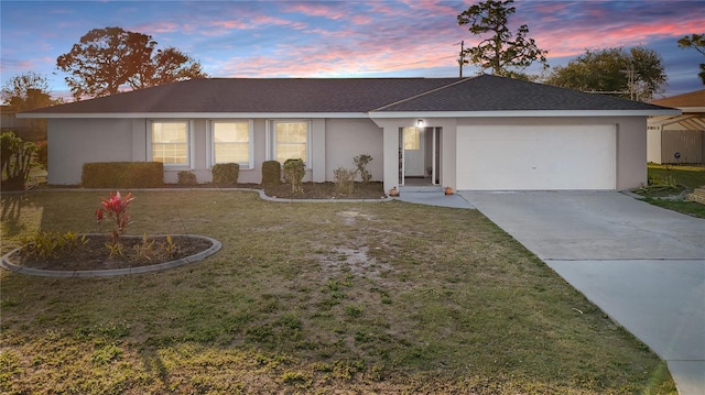 ranch-style house with driveway, a lawn, and stucco siding