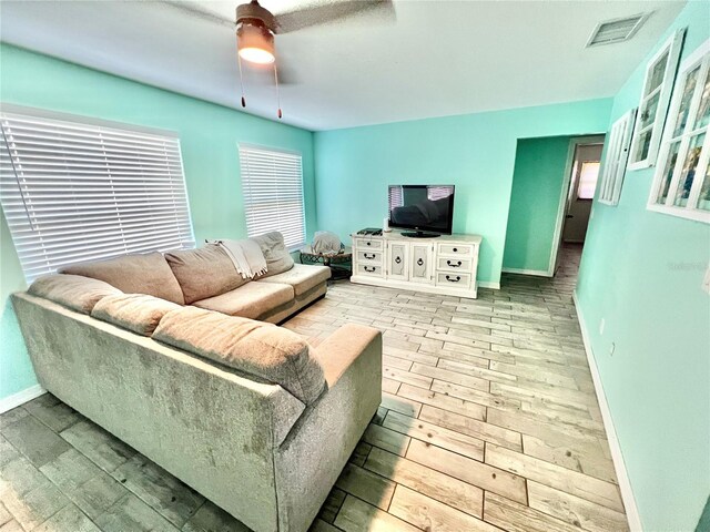3265 Sunrise Trl, Port Charlotte, FL 33952 - living room with light wood finished floors, a ceiling fan, and healthy amount of natural light
