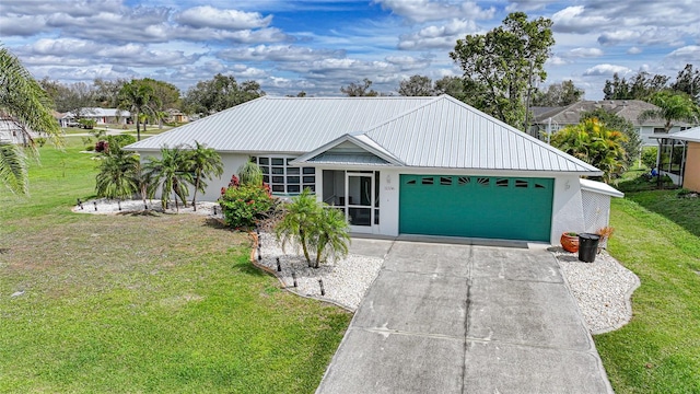 ranch-style house with driveway, a garage, metal roof, a front yard, and stucco siding