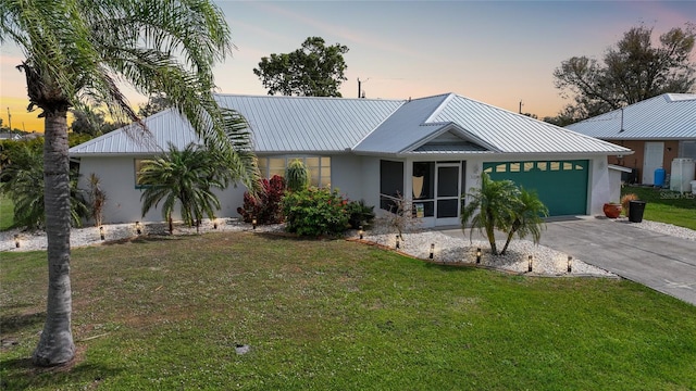 view of front of property with driveway, a yard, a garage, and stucco siding