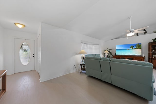 living room featuring lofted ceiling, ceiling fan, wood finished floors, and baseboards