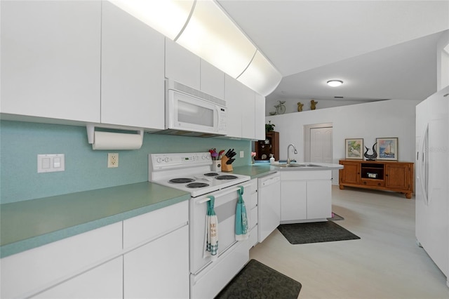 kitchen with white appliances, white cabinets, a sink, and a peninsula