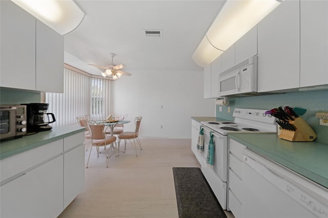 kitchen with white appliances, light wood-style flooring, visible vents, and white cabinetry