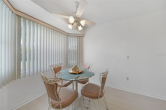 dining space featuring a ceiling fan and baseboards