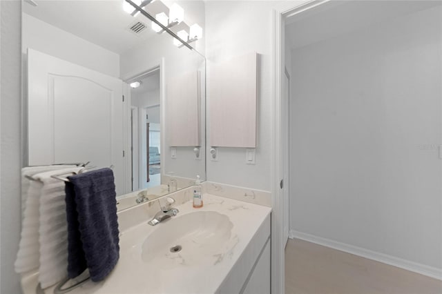 bathroom featuring visible vents, vanity, and baseboards