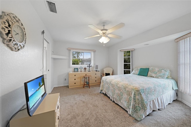 carpeted bedroom featuring baseboards, visible vents, and a ceiling fan