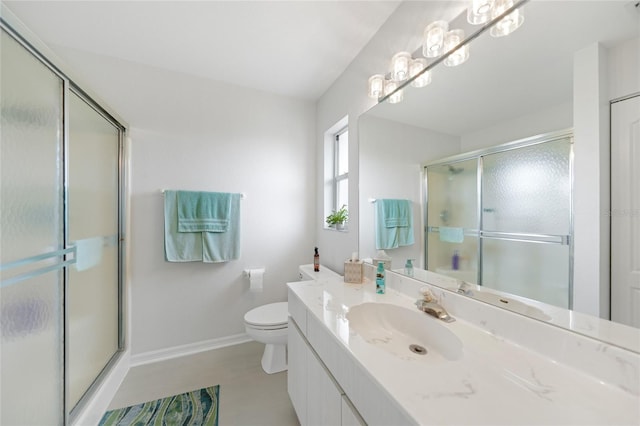 bathroom with baseboards, a shower stall, toilet, and vanity