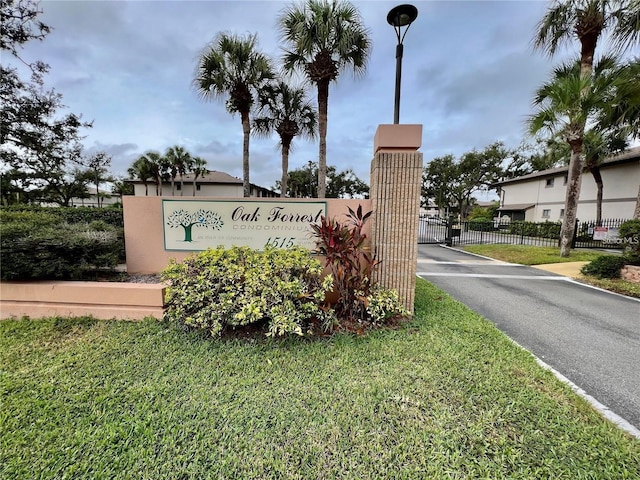 community sign featuring fence and a lawn