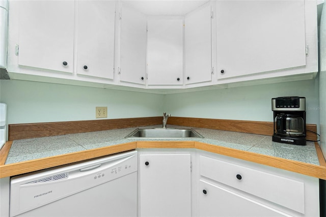 kitchen featuring tile counters, white dishwasher, white cabinetry, and a sink