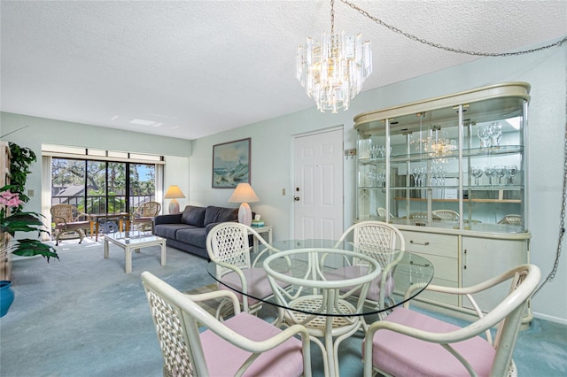 dining space featuring a textured ceiling, a chandelier, and carpet flooring