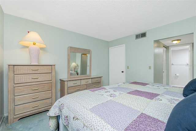 carpeted bedroom featuring a textured ceiling and visible vents