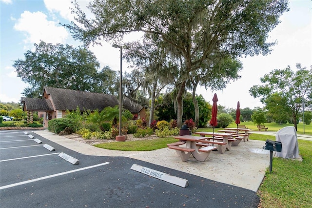 view of home's community featuring uncovered parking and a yard