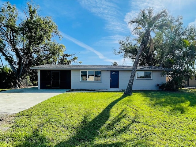 ranch-style home featuring a front lawn and concrete driveway