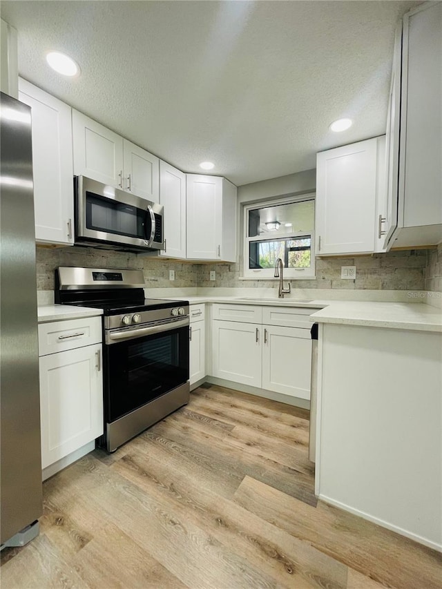 kitchen featuring light countertops, appliances with stainless steel finishes, and white cabinets