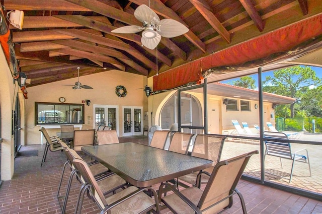 sunroom featuring vaulted ceiling with beams and ceiling fan