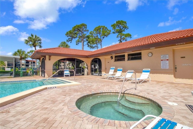 pool with a patio area, fence, and a community hot tub