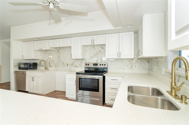 20 Palm Dr, Placida, FL 33946 - kitchen with appliances with stainless steel finishes, a sink, tasteful backsplash, white cabinets, and a ceiling fan