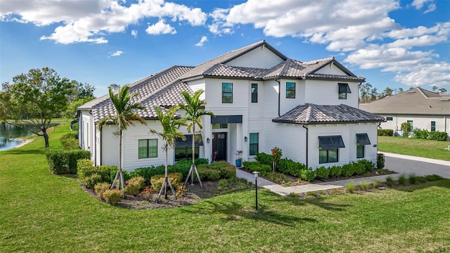 view of front of property featuring a front yard and a tiled roof