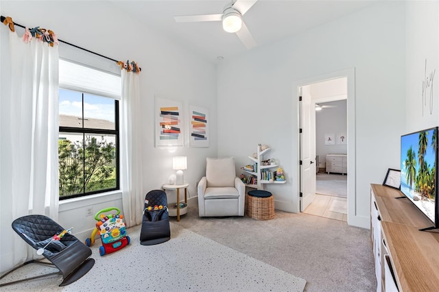 game room with a ceiling fan and light colored carpet