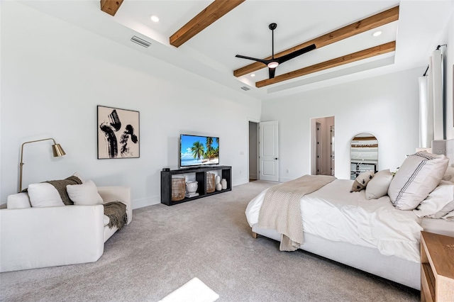 bedroom with light colored carpet, beam ceiling, visible vents, and a high ceiling