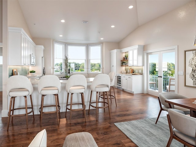 kitchen featuring lofted ceiling, light countertops, french doors, and white cabinetry