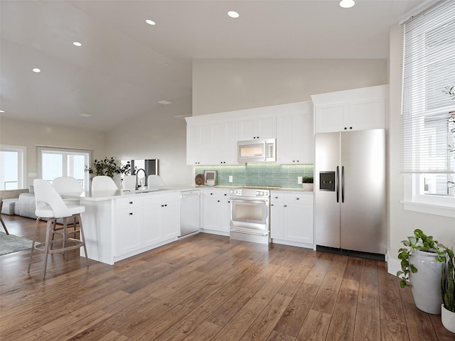 kitchen featuring appliances with stainless steel finishes, light countertops, a peninsula, and white cabinetry