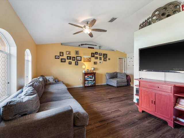 living area featuring visible vents, baseboards, dark wood-style floors, ceiling fan, and vaulted ceiling