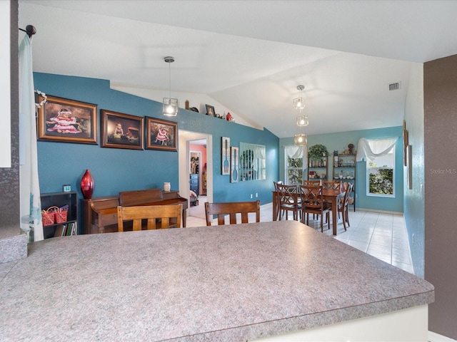 dining room with lofted ceiling, visible vents, and light tile patterned flooring