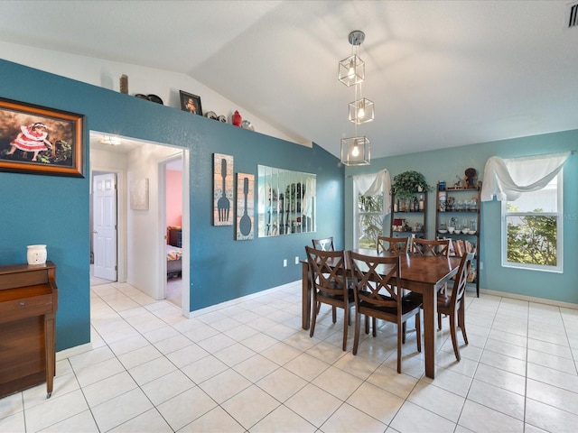 dining room with lofted ceiling, a healthy amount of sunlight, light tile patterned floors, and visible vents