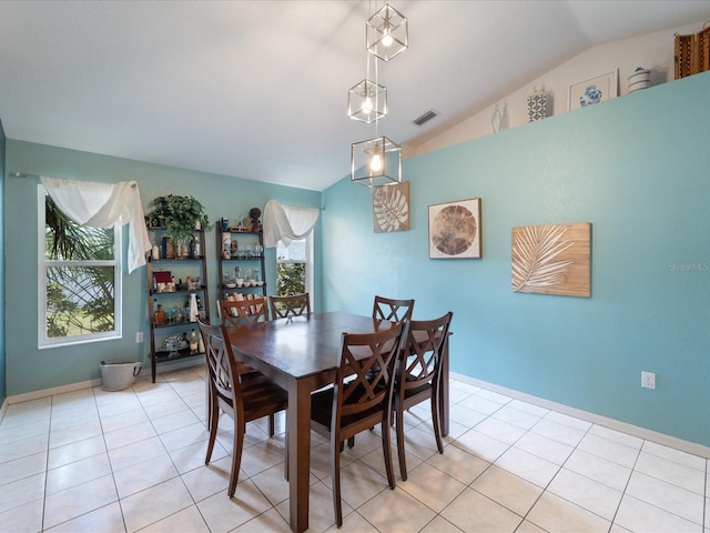 dining area with visible vents, vaulted ceiling, baseboards, and light tile patterned floors