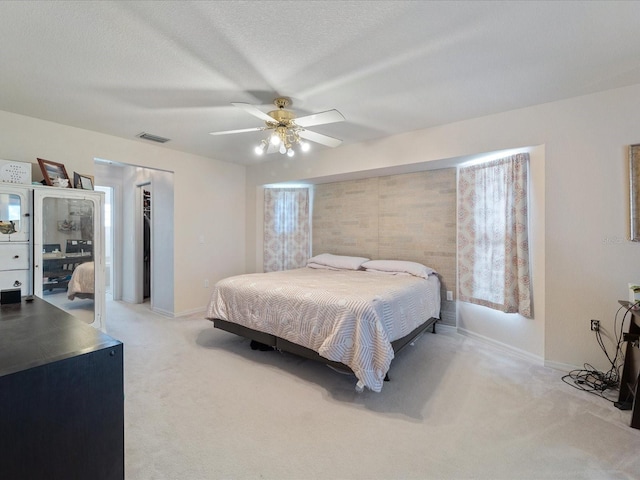 bedroom featuring light carpet, a textured ceiling, a closet, and visible vents