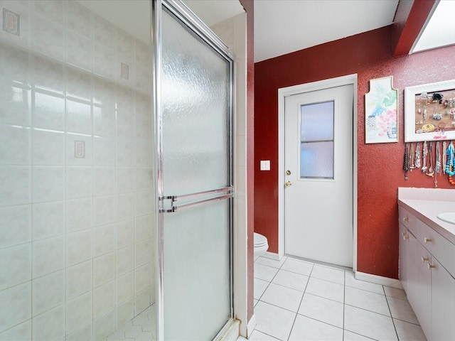 full bath featuring a stall shower, tile patterned flooring, vanity, and toilet