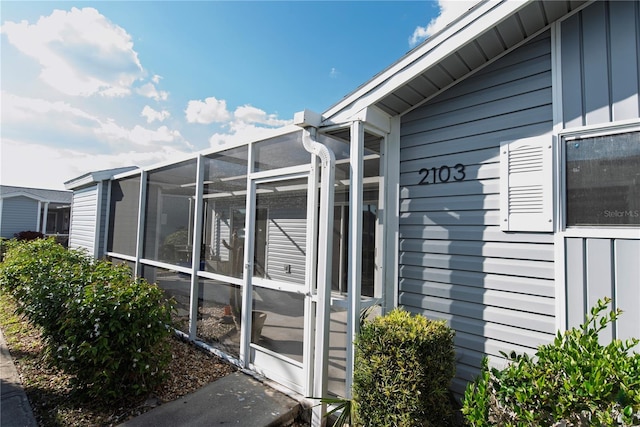 view of home's exterior with a sunroom and board and batten siding