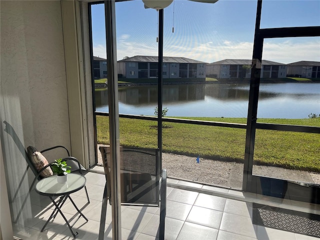 sunroom / solarium featuring a water view and a residential view