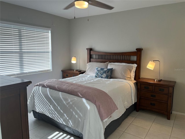 bedroom with a ceiling fan, baseboards, and light tile patterned floors