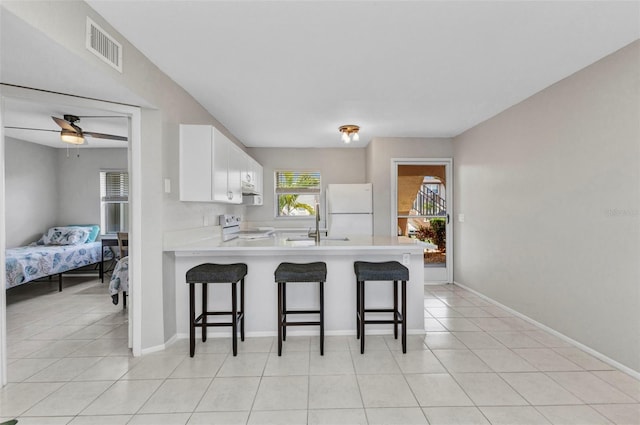 25100 Sandhill Blvd Unit R104, Punta Gorda, FL 33983 - kitchen featuring stove, freestanding refrigerator, a peninsula, light countertops, and a breakfast bar area