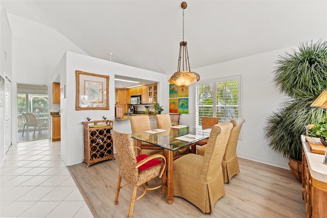 12130 Siesta Dr, Fort Myers Beach, FL 33931 - dining space with vaulted ceiling, light tile patterned floors, and a healthy amount of sunlight