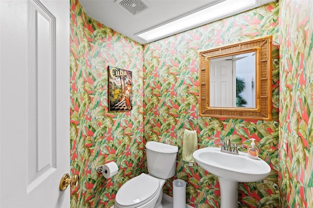 12130 Siesta Dr, Fort Myers Beach, FL 33931 - half bathroom with visible vents, toilet, and wallpapered walls