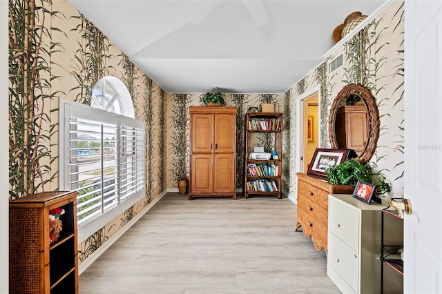 12130 Siesta Dr, Fort Myers Beach, FL 33931 - sitting room with lofted ceiling, a healthy amount of sunlight, light wood-style flooring, and wallpapered walls