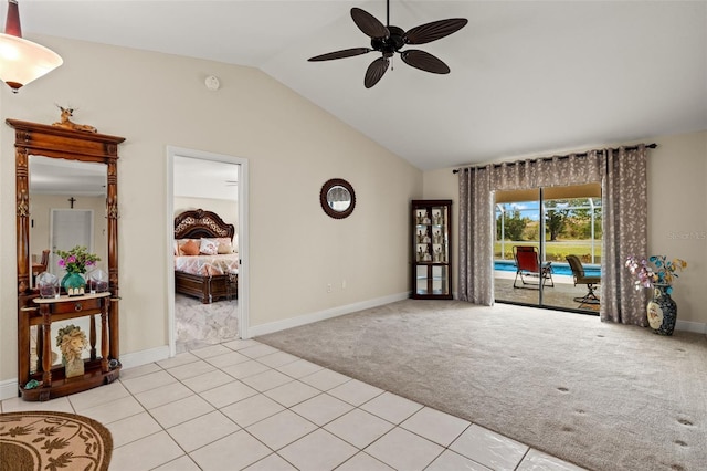 interior space featuring light carpet, lofted ceiling, a ceiling fan, light tile patterned flooring, and baseboards