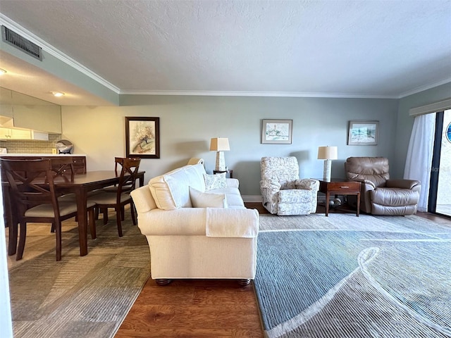 living room featuring crown molding, a textured ceiling, visible vents, and dark wood-style flooring