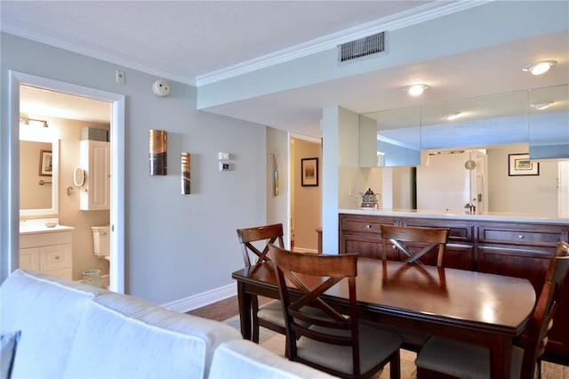 dining area with ornamental molding, visible vents, baseboards, and wood finished floors